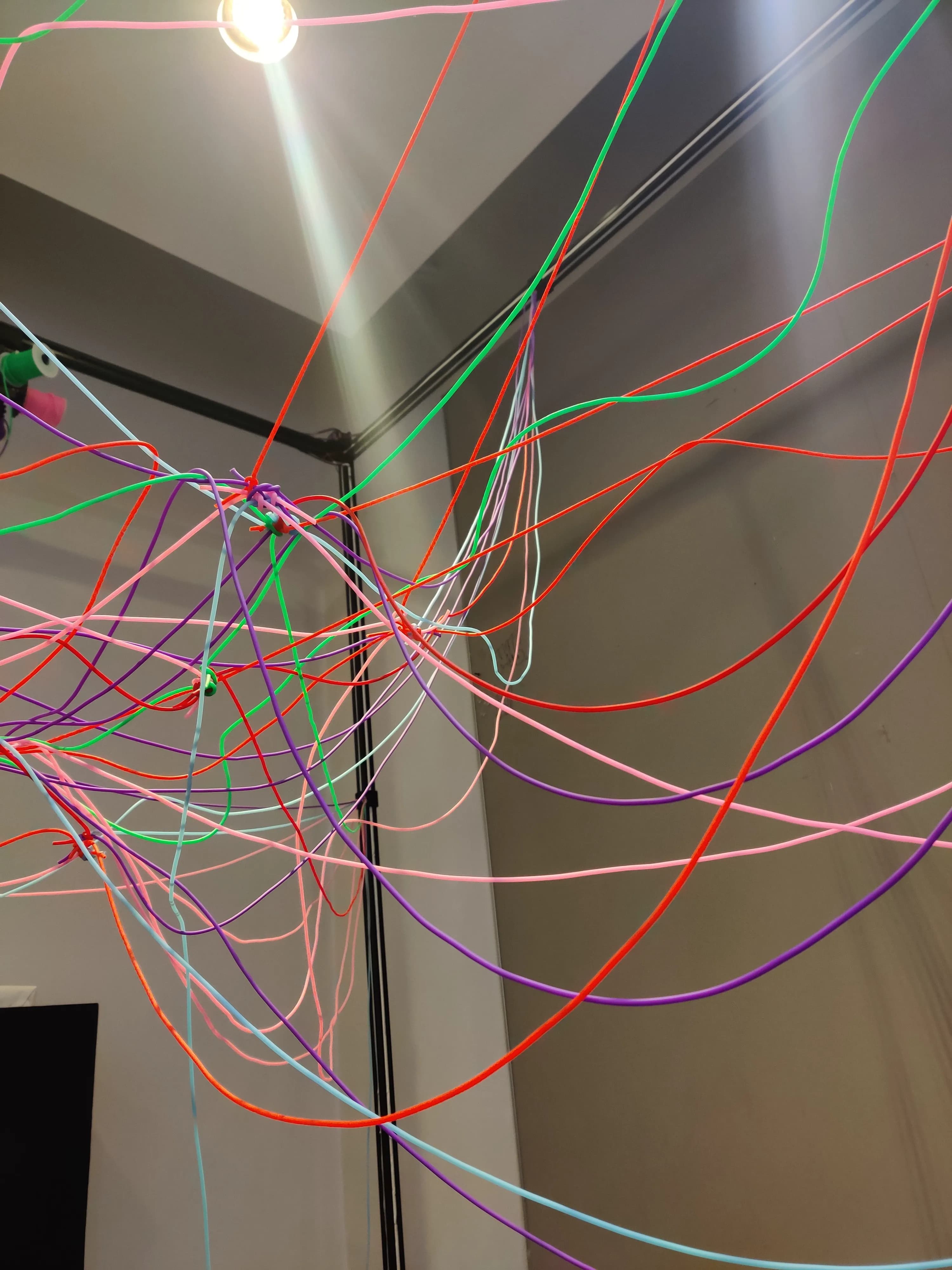 Looking up inside the frame at the dense colorful web of accumulated threads